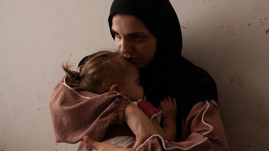 einab Ozeir, 29, calms the cries of Abbas, her 1.5-year-old son, in a room where she lives with her husband and their 4 children in the Azarieh shelter in central Beirut.