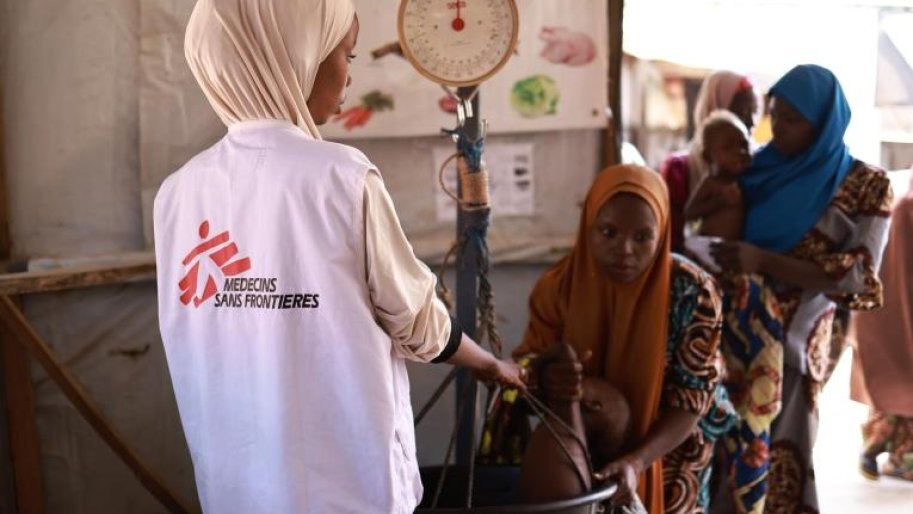 Un membre du personnel MSF prend le poids d'un enfant au centre nutritionnel thérapeutique ambulatoire Kofar Marusa, à Katsina, dans l'État de Katsina.