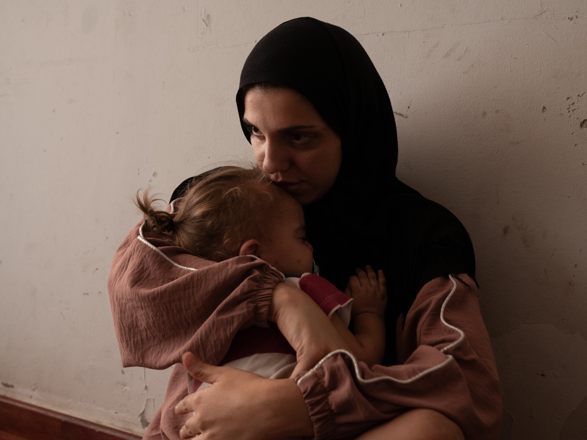 einab Ozeir, 29, calms the cries of Abbas, her 1.5-year-old son, in a room where she lives with her husband and their 4 children in the Azarieh shelter in central Beirut.