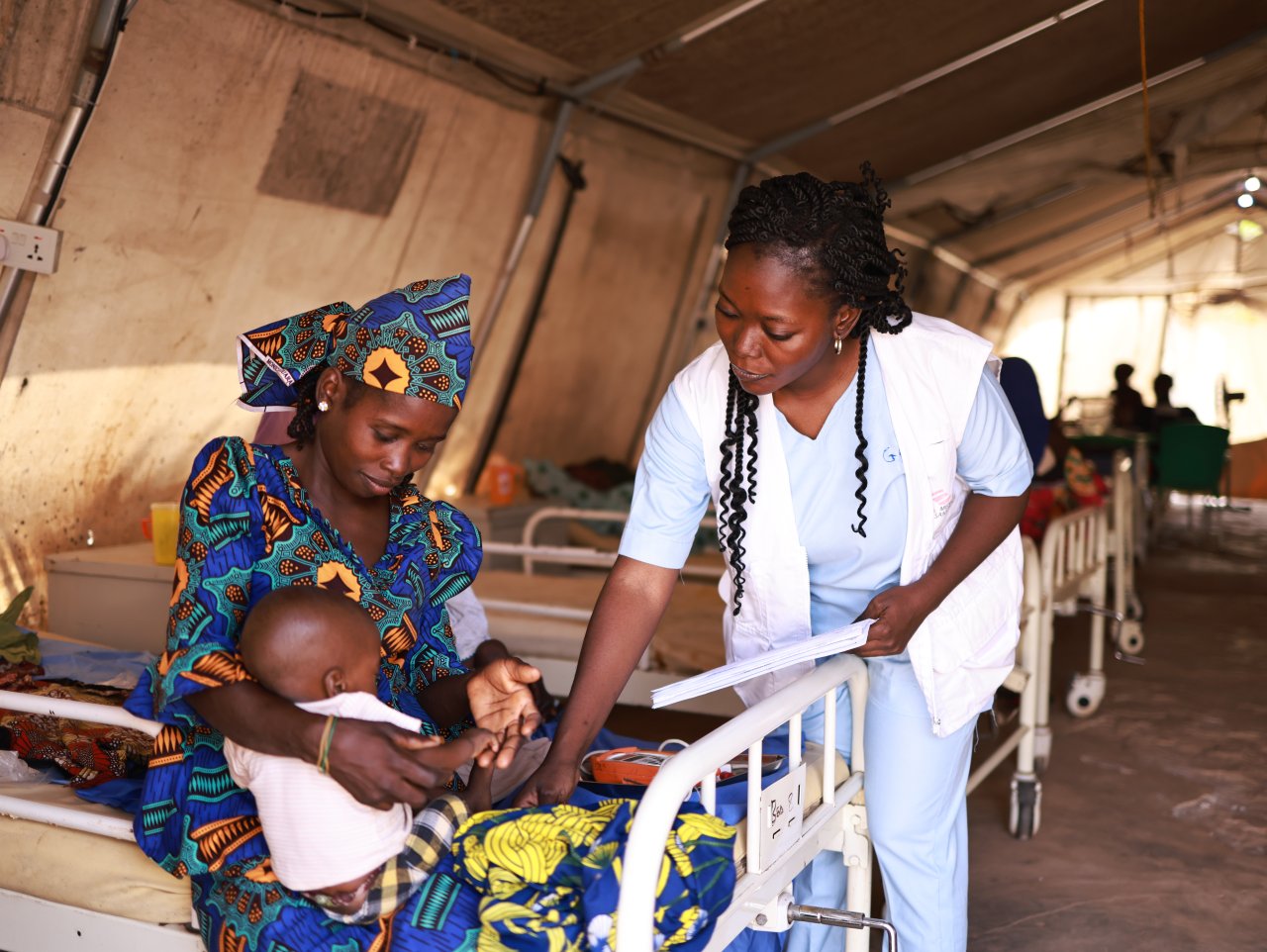 Le personnel MSF prend les signes vitaux de Nura, l'enfant de Zainab, au centre d'alimentation thérapeutique de Kofar Suari, à Katsina, dans l'État de Katsina. Nura est traité pour malnutrition. Il y a quelques jours, il ne pouvait prendre que du lait thérapeutique. Aujourd'hui, il peut prendre des aliments thérapeutiques. 