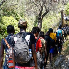 Des personnes nouvellement arrivées marchent sur un chemin rocheux sur l'île de Samos, en Grèce.