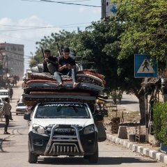 Des Palestiniens déplacés à Rafah, dans le sud de la bande de Gaza, transportent leurs effets personnels alors qu'ils quittent les lieux suite à un ordre d'évacuation de l'armée israélienne, le 6 mai 2024. 