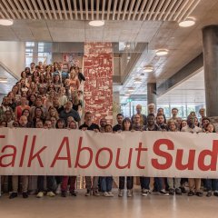 Personnel du siège de MSF Suisse tenant une banderole "#TalkAboutSudan" en soutient à la population soudanaise.