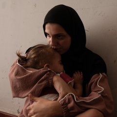 einab Ozeir, 29, calms the cries of Abbas, her 1.5-year-old son, in a room where she lives with her husband and their 4 children in the Azarieh shelter in central Beirut.