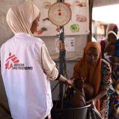 Un membre du personnel MSF prend le poids d'un enfant au centre nutritionnel thérapeutique ambulatoire Kofar Marusa, à Katsina, dans l'État de Katsina.