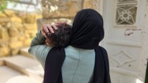 Palestinian woman holding her child in West Bank.